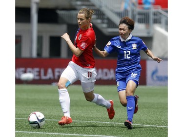 Norway's Nora Holstad Bergen (11) defends the ball against an attacking Rattikan Thongsombut (12) of Thailand during the first half of their first match of the FIFA Women's World Cup at TD Place in Ottawa Sunday June 07, 2015.