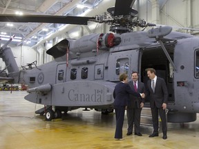 Public Works Minister Diane Finley, left to right, Defense Minister Jason Kenney and Justice Minister Peter MacKay shake hands during a photo op in front of CH-148 Cyclone helicopter at 12 Wing Shearwater in Shearwater, N.S., on Friday, June 19, 2015.
