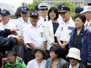 Senator Yonah Martin (C) and Korean war veterans along with their families gather for a group photo at the 62nd anniversary of the Korean War Armistice at Monument to Canadian Fallen in Ottawa on Sunday, June 21, 2015.