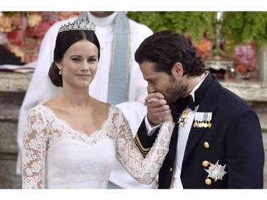 Sweden's Prince Carl Philip, right, kisses Sofia Hellqvist's hand during their wedding ceremony at the Royal Chapel in Stockholm Palace on June 13, 2015.