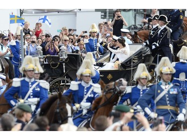 Sofia Hellqvist (R) and Sweden's Prince Carl Philip ride in a horse-drawn carrige after their wedding at Stockholm Palace on June 13, 2015.