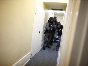 Tactical unit police officers throw a stun grenade before entering a room at an abandoned heritage building in Ottawa. The Ottawa Citizen took a ride-along with Ottawa police tactical unit on a Friday night, May 15, 2015.