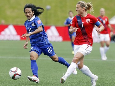 Thailand's Kanjana Sung-Ngoen (21) challenges Trine Ronning (7) for the ball during the first half of their first match of the FIFA Women's World Cup at TD Place in Ottawa Sunday June 07, 2015.