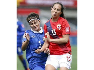 Thailand's Natthakarn Chinwong (3) and Ingrid Moe Wold (13) collide during the second half of their first match of the FIFA Women's World Cup at TD Place in Ottawa Saturday June 07, 2014. Norway won 4-0.