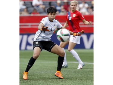 Thailand's Waraporn Boonsing (1) keeps her eye on a loose ball as Norway's Ada Hegerberg (21) looks on in the back ground during the second half of their first match of the FIFA Women's World Cup at TD Place in Ottawa Saturday June 07, 2014. Norway won 4-0.