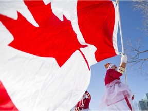 The Colour Guard Clowns from the Ottawa Stilt Union wave the Maple Leaf flag at Confederation Park following a ceremony marking the 50th anniversary of the Canadian Flag in Ottawa on Sunday, Feb. 15, 2015.