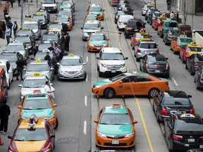 Taxi divers block traffic during a protest against Uber on Queen Street in front of City Hall in Toronto, Ontario, Monday June 1, 2015.