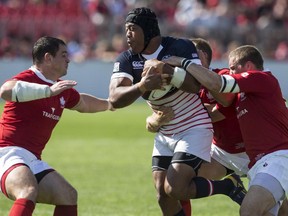 USA's Andrew Suniula (centre) runs at Canada's defence during first half Rugby World Cup qualifying action in 2013.