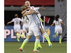 The U.S.A.'s Julie Johnston and Becky Sauerbrunn (4) celebrate a goal against China by teammate Carli Lloyd during the second half of a World Cup quarter-final in Ottawa on Friday, June 26, 2015.