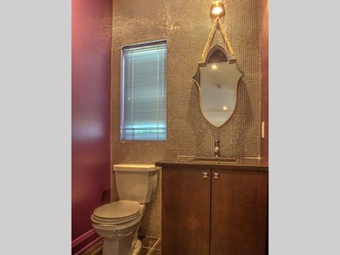 A wall of tiny silver tiles in the purple powder room is just one of several elegant surprises.