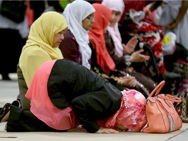 A group of women pray at an area set aside between the games and shopping booths at the EY Centre, July 17, 2015.  The Muslim Summer festival is on at Ey Centre again for Eid al-Fitr, the end of Ramadan, July 6, 2016..