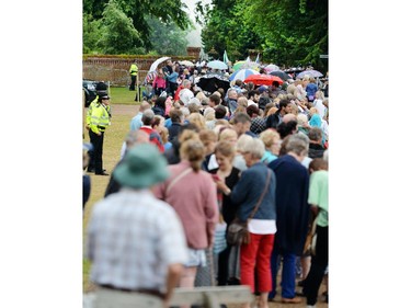 A large crowd of loyal royal fans pass through security to the area around the Church of St Mary Magdalene in Sandringham, eastern England, where Princess Charlotte will be christened in front of the Queen and close family, Sunday July 5, 2015. The church, close to William and Kate's country house Anmer Hall, is where the royal family traditionally gathers for Christmas service. It is also where Charlotte's late grandmother, Princess Diana, was christened in 1961.