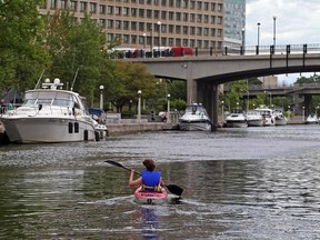A tourist uses her sea kayak to tour the Rideau Canal in July.
