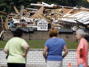 Area residents look at the remnants of 130-year-old St. Sixte Catholic Church that was destroyed by fire Monday evening Tuesday July 07, 2015.