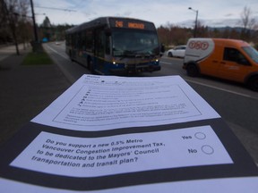 A ballot for the proposed transit tax is displayed as a bus passes by on West Georgia Street in Vancouver, B.C., on Tuesday March 17, 2015. Referendum ballots began being sent out to Metro Vancouver voters this week with mail-in voting to take place until May 29 on a proposed 0.5% increase in the PST to fund transit projects.