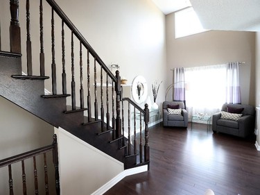 A dark oak stairway and open-to-above living room add presence to the Bordeaux.