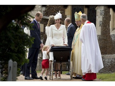 Prince George of Cambridge looks at his sister as his mother, Britain's Catherine, Duchess of Cambridge, father Prince William, Duke of Cambridge (L), and Archbishop of Canterbury Justin Welby (2nd R) look on, as they leave Charlotte's Christening at St. Mary Magdalene Church in Sandringham, England, on July 5, 2015. Britain's baby Princess Charlotte was christened on Sunday outside Queen Elizabeth II's country residence on Sunday.