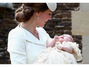 Britain's Catherine, Duchess of Cambridge, carries her daughter, Princess Charlotte of Cambridge after taking her out of a pram as they arrive for Charlotte's Christening at St. Mary Magdalene Church in Sandringham, England, on July 5, 2015. Crowds gathered outside Queen Elizabeth II's country residence on Sunday for the christening of Britain's baby Princess Charlotte, who it was announced will have five godparents.