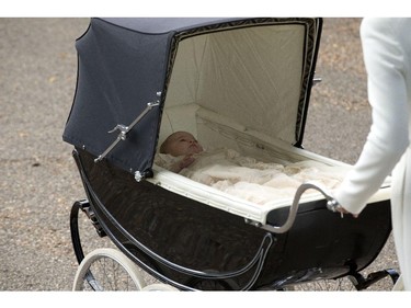 Britain's Princess Charlotte is pushed in a pram by her mother Kate the Duchess of Cambridge as they arrive for Charlotte's Christening at St. Mary Magdalene Church in Sandringham, England, Sunday, July 5, 2015.