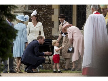 Britain's Queen Elizabeth II speaks to Prince George beside his father Prince William, next to Kate the Duchess of Cambridge with Princess Charlotte in a pram and Camilla the Duchess of Cornwall, left, as they leave after attending the Christening of Britain's Princess Charlotte at St. Mary Magdalene Church in Sandringham, England, Sunday, July 5, 2015.