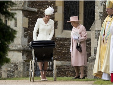 Britain's Queen Elizabeth II stands with Kate the Duchess of Cambridge whilst pushing Princess Charlotte in a pram as they leave after attending the Christening of Britain's Princess Charlotte at St. Mary Magdalene Church in Sandringham, England, Sunday, July 5, 2015.