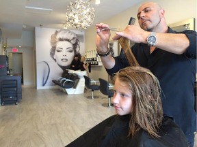 Bruce Saikaley, co-owner of Silver Scissors, gives a haircut to Keira Lawson, 11, who has been coming to the Glebe hair salon with her mother for nine years.
