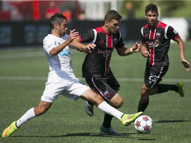 Ryan Richter (C) of the Ottawa Fury FC vias for the ball with Carolina RailHawks Austin da Luz (L) during the teams NASL game at TD Place in Ottawa, July 26, 2015.