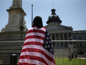 South Carolinan Brenda Brisbon wears the "Stars and Stripes" after the Confederate "Stars and Bars" was lowered from the flagpole in front of the statehouse on July 10, 2015 in Columbia, South Carolina. Republican Governor Nikki Haley presided over the flag-lowering event after signing the historic legislation to remove the flag the day before.