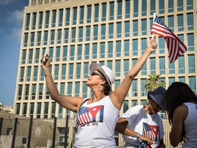 A tourist makes a selfie holding a US Flag in front of the US Embassy in Havana, on July 20, 2015.