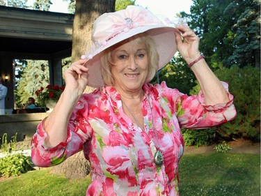 Elisabeth Carioto tries on the fancy new hat that she won at the 20th Annual Garden Party for Opera Lyra Ottawa, held in Gatineau at the official residence of the Italian ambassador on Wednesday, July 8, 2015.