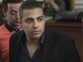In this Thursday, June 25, 2015 file photo, policemen accompany Canadian Al-Jazeera English journalist Mohammed Fahmy during his retrial at a courtroom in Tora prison in Cairo, Egypt. Egypt's government is pushing through a controversial new anti-terrorism draft bill that would set up special terrorism courts, shorten the appeals process, give police greater powers of arrest and imprison journalists who report information on attacks that differs from the official government line, a judicial official said Monday, July 6.