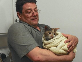 Nick St. Laurent dries off Babies after the cat was rescued from an apartment fire.