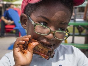 George Ronzio, 4, enjoys lunch at Capital Ribfest at city hall's Festival Plaza on Friday.