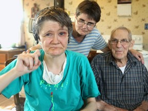 Jennifer James is severely autistic and wears headphones to block distracting sound. Her sister, Caroline, centre, served as  Jennifer's caregiver until jennifer went into a residential facility last fall after the death last year of their father, Arnold, right.