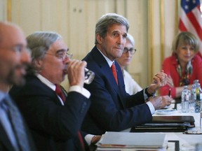 U.S. Secretary of State John Kerry, centre, meets with Iranian Foreign Minister Mohammad Javad Zarif in Vienna, Austria, Friday July 3, 2015.  Iran has committed to implementing the IAEA's "additional protocol" for inspections and monitoring as part of an accord, but the rules don't guarantee international monitors can enter any facility including sensitive military sites, so making it difficult to investigate allegations of secret work on nuclear weapons.
