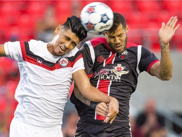 Jamie Chavez, left, and Rafael Alves head the ball.