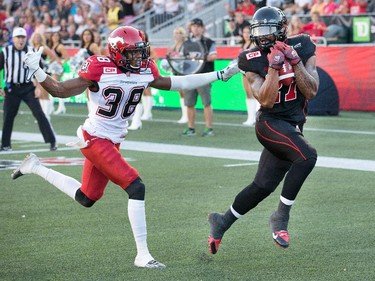 Jeremiah Johnson holds onto the ball for the two point conversion with Calgary player Buddy Jackson moving in.