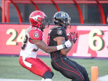 Jeremiah Johnson holds onto the ball for the two point conversion with Calgary player Buddy Jackson moving in.