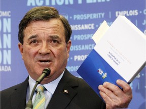 Then-finance minister Jim Flaherty brandishes a copy of the 2012 budget.