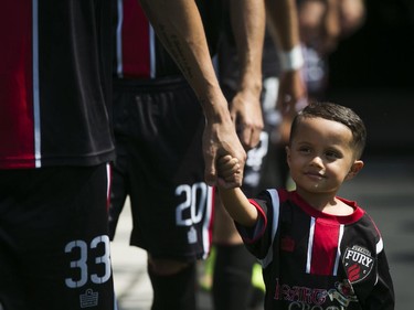 Joao son of Ottawa Fury FC Rafael Alves is seen holding his father's hand prior to the start of the game against  the Carolina RailHawks in Ottawa, July 26, 2015.