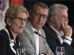 Ontario Premier Kathleen Wynne, left, fields a question as Newfoundland and Labrador Premier Paul Davis and Quebec Premier Philippe Couillard, right, look on at the closing news conference of the summer meeting of Canada's premiers in St. John's on Friday, July 17, 2015.