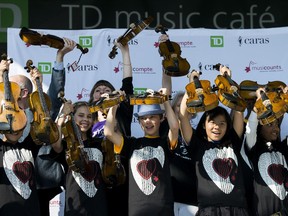 Members of OrKidstra hold some of the instruments MusiCounts TD Community Music Program donated.