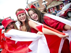 From left, Kayla Landry, 15, Isabelle Latour, 14, and Michaela Scanlon, 15, are draped in red and white while celebrating Canada Day in Ottawa's downtown core Wednesday July 1, 2015.