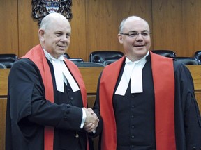Associate Chief Justice John Rooke congratulating Justice Russell Brown at Brown's swearing-in as a judge of Her Majesty's Court of Queen's Bench of Alberta, in February 2013