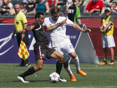 Paulo Junior, left, of the Ottawa Fury fights for the ball against the Carolina RailHawks during an NASL game at TD Place on July 26, 2015.