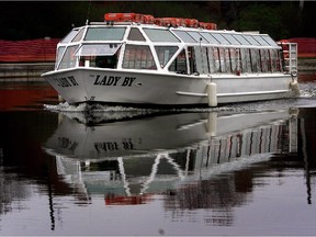 The 'Lady By' tour-cruise boat heads downtown as the Rideau Canal opens for navigation on Victoria Day, May 5, 2004.