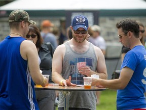Left to right, Patrick Millington, Kyle O'Murphy and Derek Watkins play some cards as they enjoy a cold one in the park on Saturday, July 25, 2015.