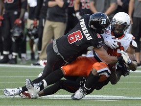 Ottawa Redblacks' Antoine Pruneau (6) and Jerrell Gavins (24) stop B.C. Lions fullback Rolly Lumbala during second half CFL action in Ottawa this past Saturday.