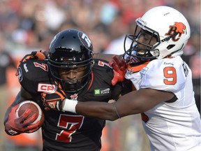 The Ottawa Redblacks' Maurice Price is stopped by the B.C. Lions' Chris Rwabukamba during first-half action at TD Place in Ottawa on Saturday, July 4, 2015.