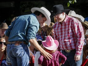 Prime Minister Stephen Harper, right, meets Liberal leader Justin Trudeau, left, and his daughter Ella-Grace while attending the Calgary Stampede parade last year. The stakes are higher this year, as Mark Kennedy reports.